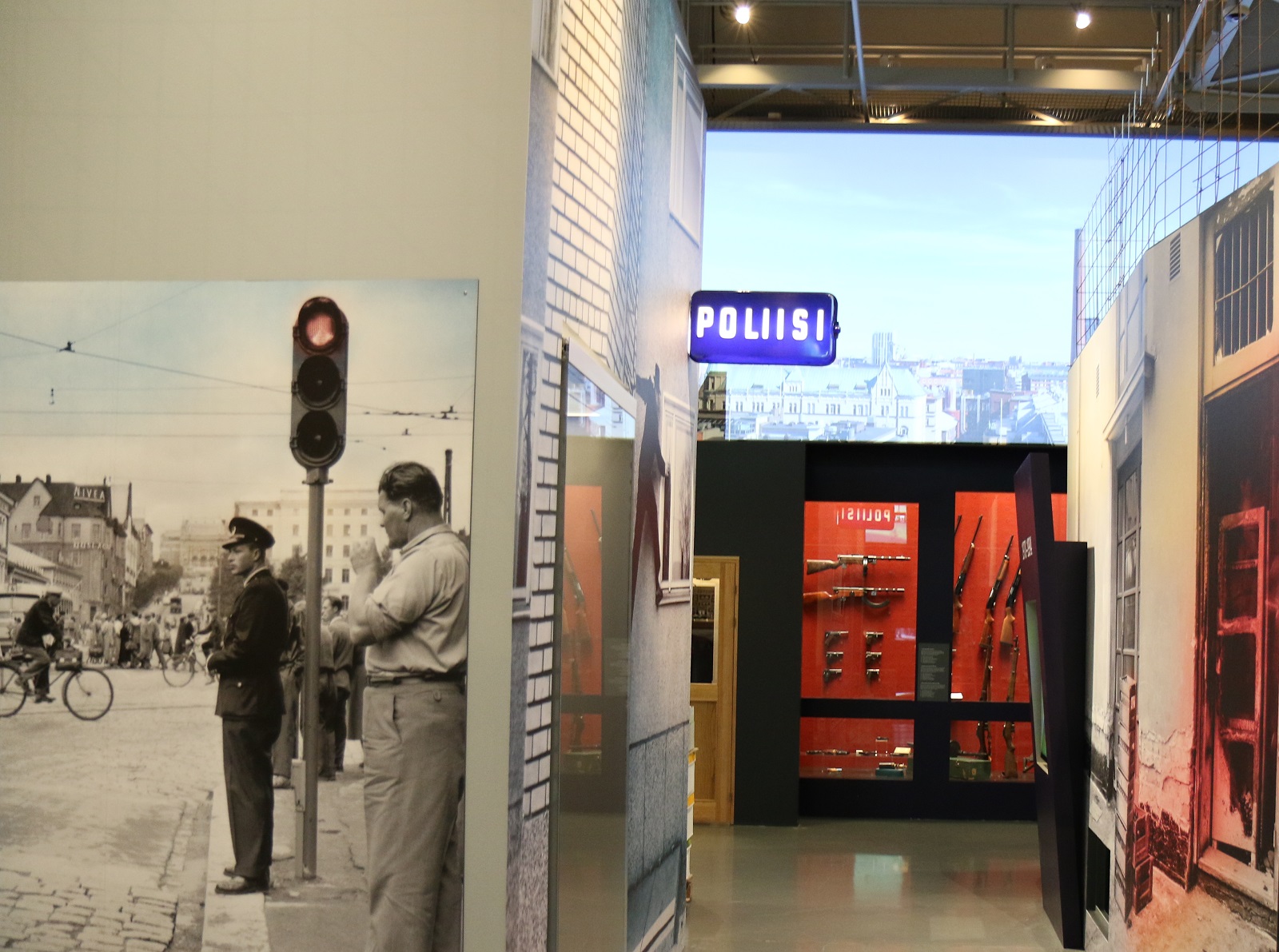 Allmän bild av Polismuseets utställning. På bilden syns bland annat en polisskylt och ett stadslandskap. Bild Polismuseet, Jarkko Järvinen.