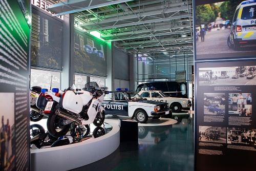 Yleiskuva Poliisimuseon erikoisnäyttelystä, jossa on esillä muun muassa poliisin autoja ja moottoripyöriä.