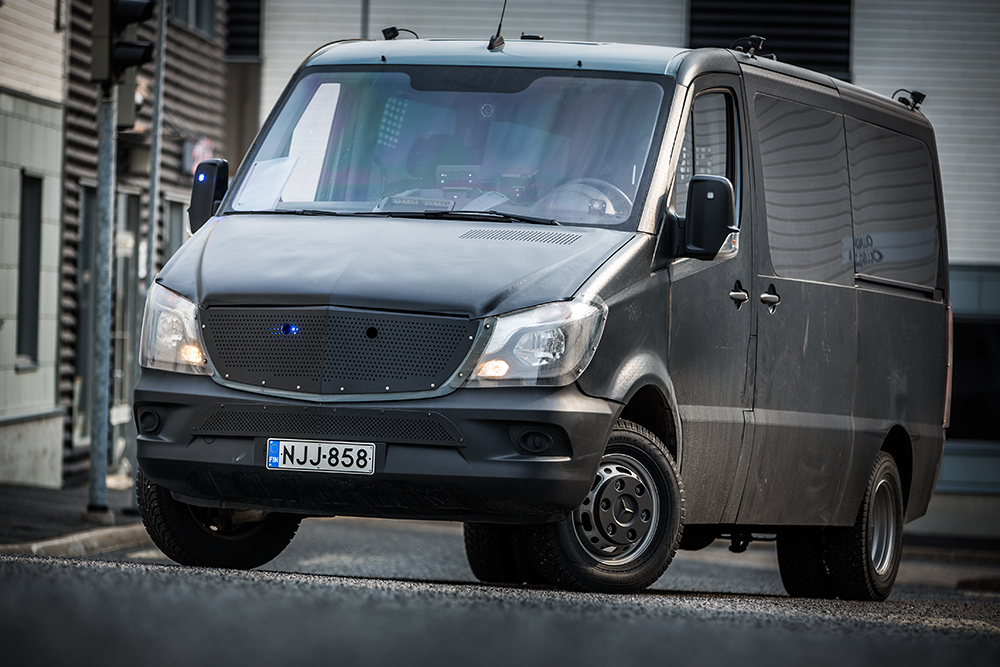 A dark van standing on the road in an urban landscape.