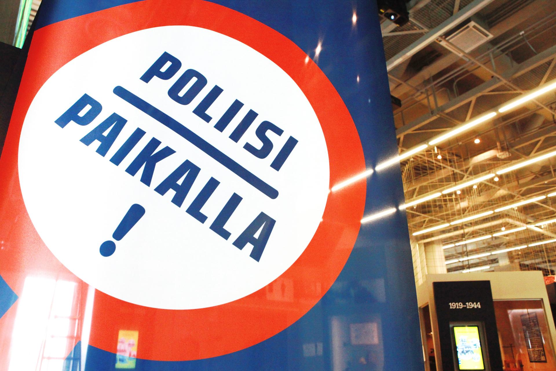 Exhibition logo in the museum facilities, with the text: Poliisi paikalla! (The Police is Here!).  
