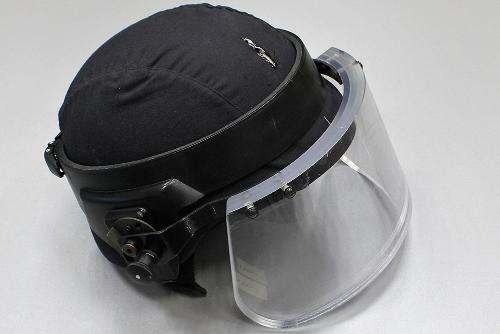 Helmet with a cut in the protective fabric and an impact mark on the protective visor.