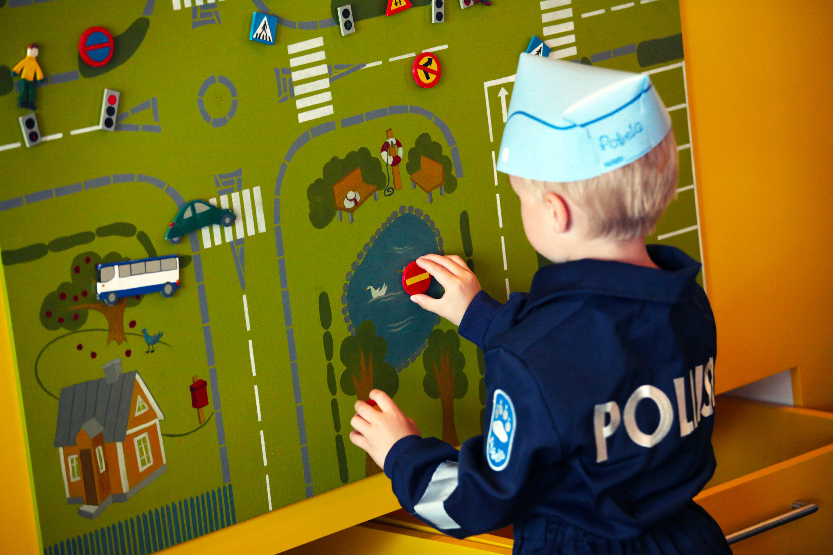 A child playing the traffic game in Pokela, wearing police overalls. Photo The Police Museum.