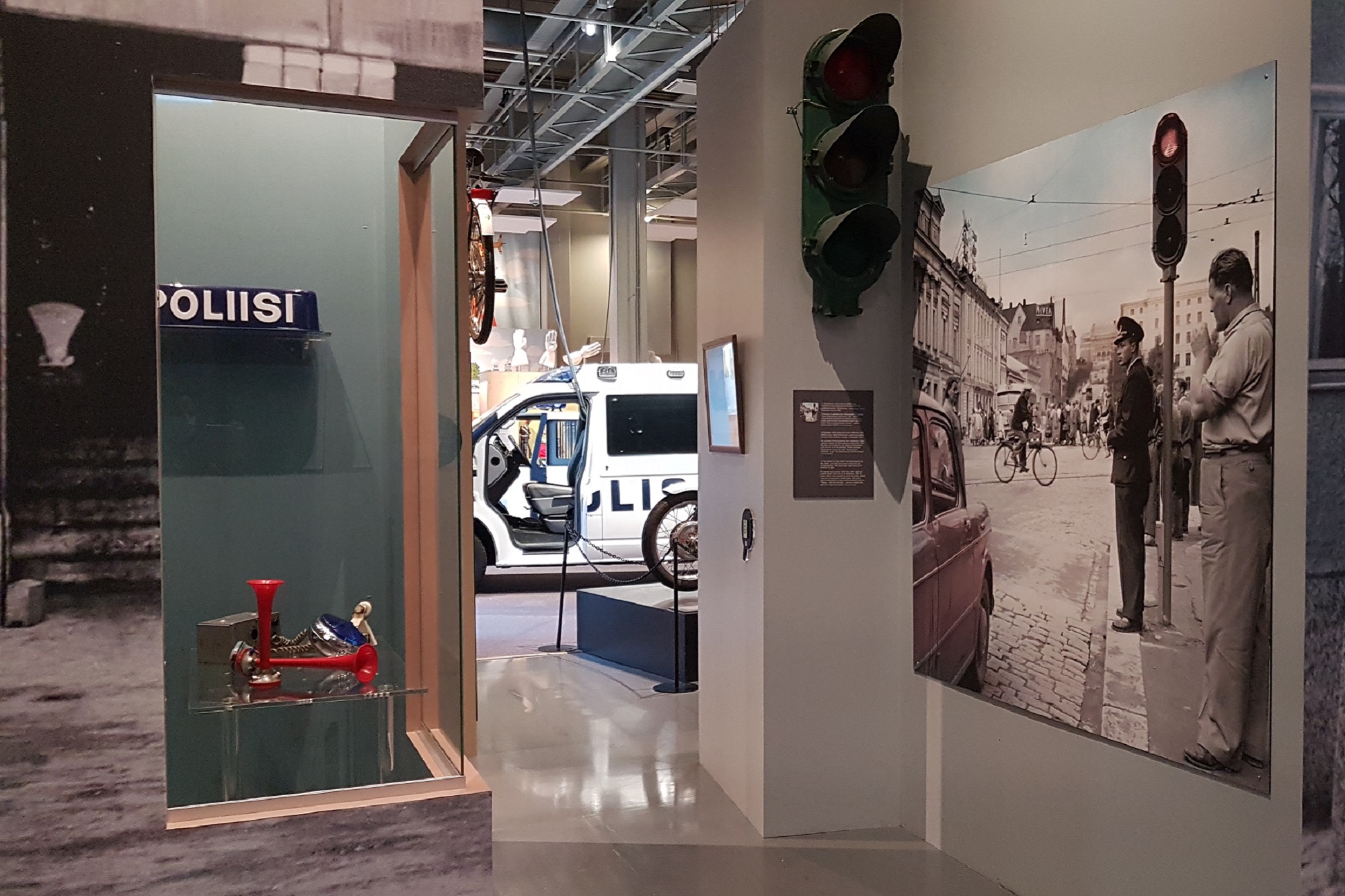 A view of the Museum’s exhibition. The picture shows a showcase, a photograph of city traffic and a police car. Photo the Police Museum, Pia Penttilä