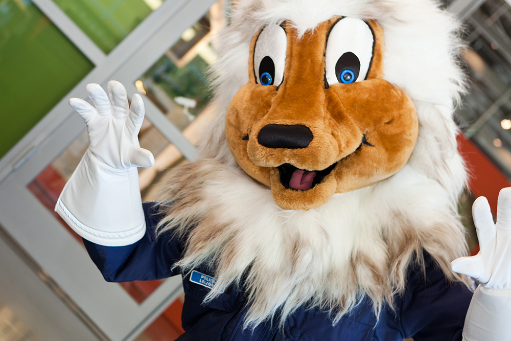 The police lion mascot waves to the camera.