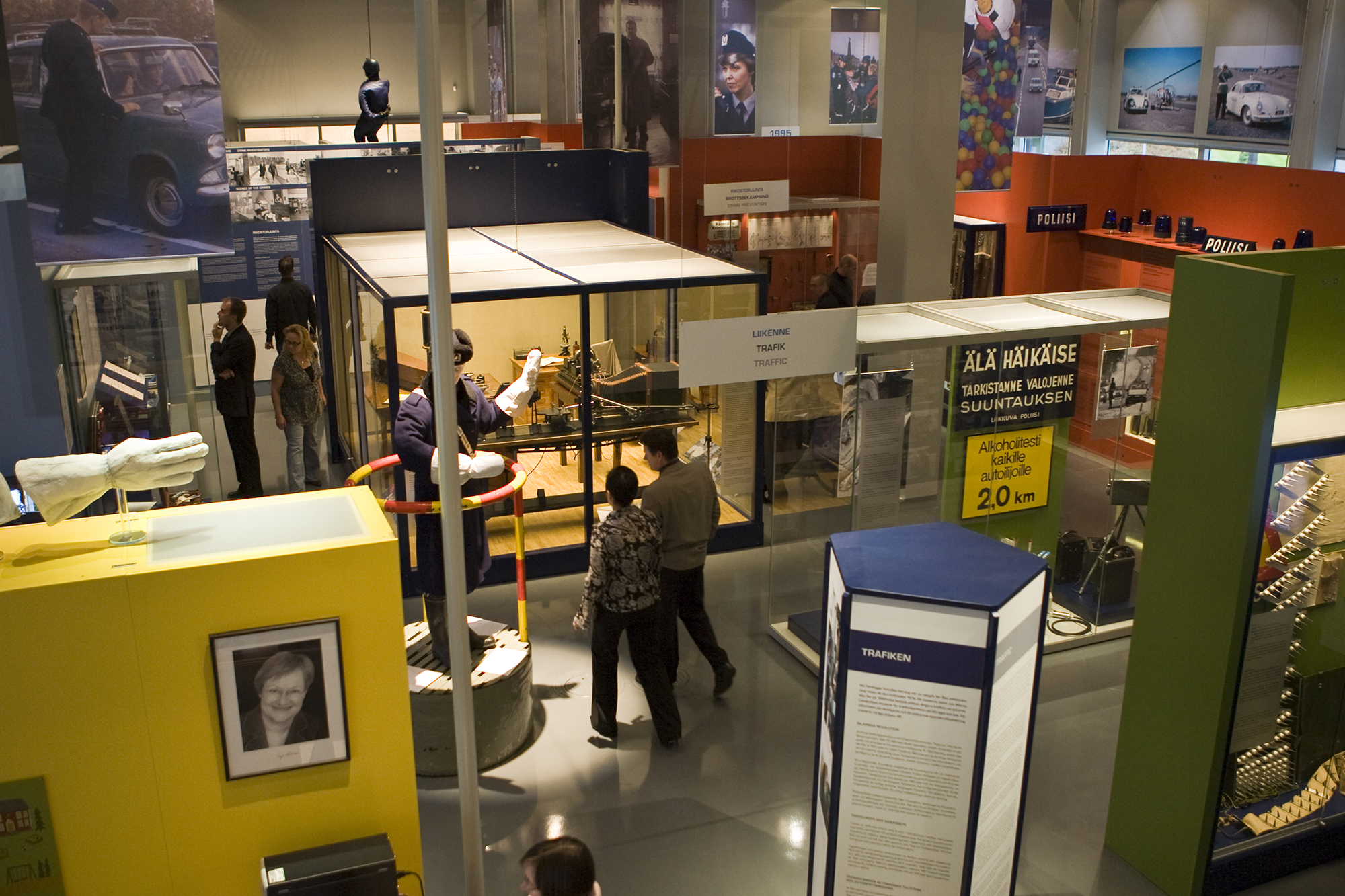 General view of the Police Museum’s exhibition. The picture shows museum visitors walking between the showcases, and in the room, for example photographs and items relating to police work are seen. Photo the Police Museum