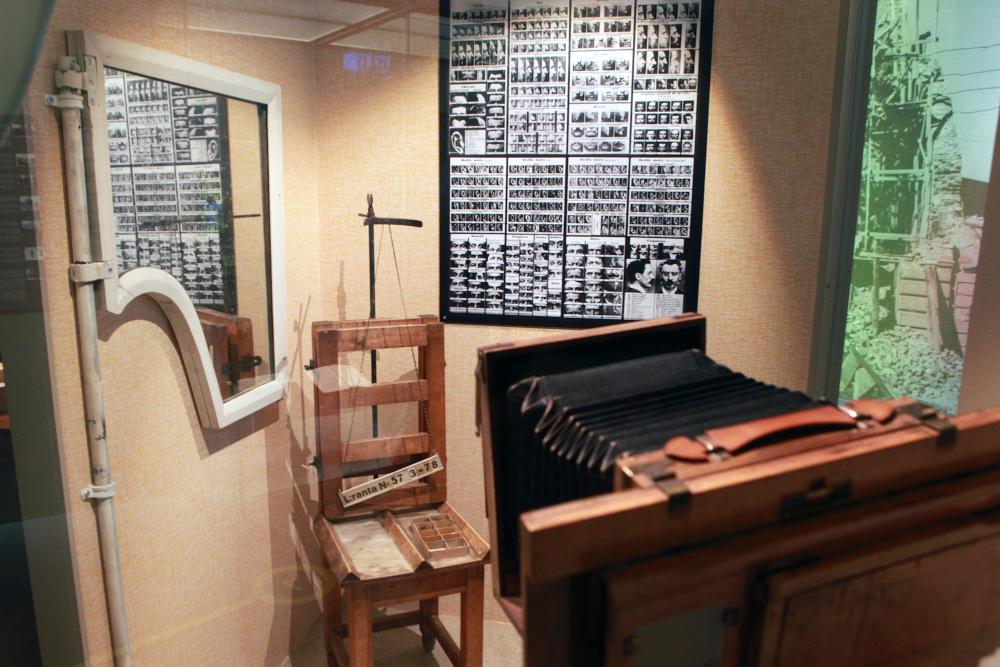 An old camera and a chair in which suspects were photographed for police records.