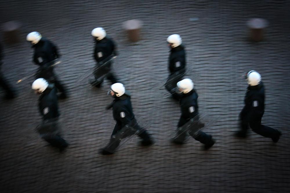 Valokuva näyttelystä, kuvassa joukkojenhallintapoliiseja kävelemässä kahdessa jonossa.