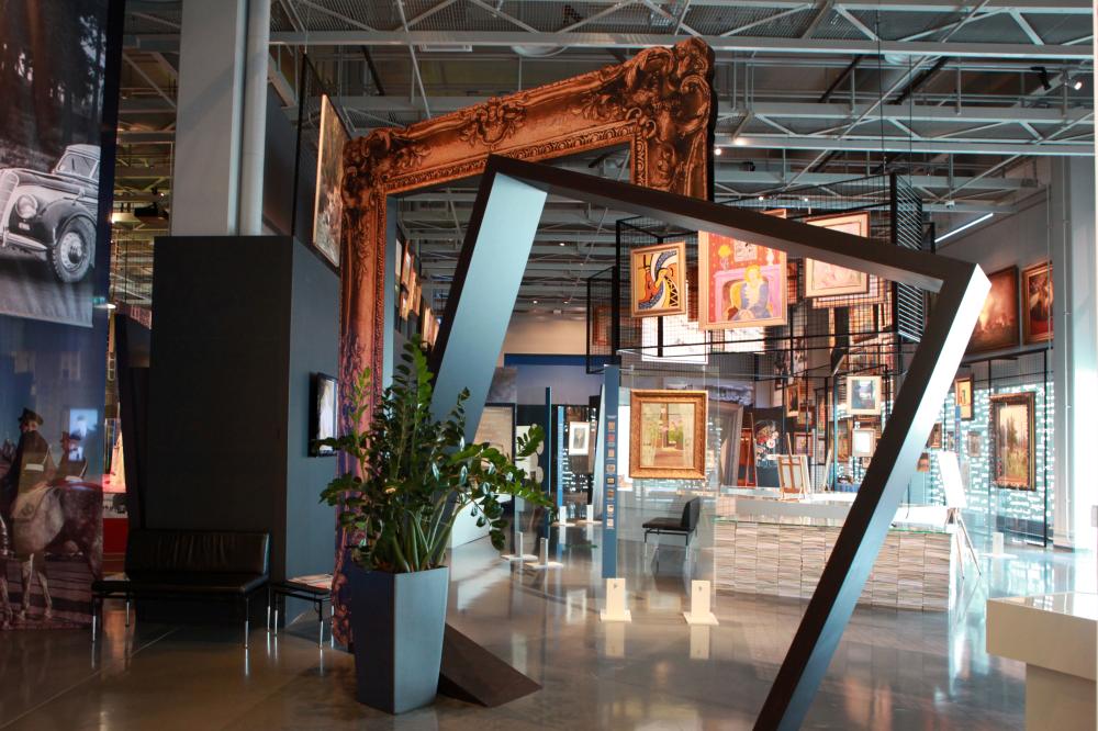 Bild av museets utställning om konstbrott. På bilden syns bland annat tavelramar som når ända från golv till tak och tiotals förfalskade tavlor på väggar och i en upphängningsställning.